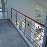 Wangentreppe in weiß, mit Eichenstufen und einem Geländer aus Edelstahl