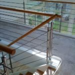 Wangentreppe in weiß, mit Eichenstufen und einem Geländer aus Edelstahl